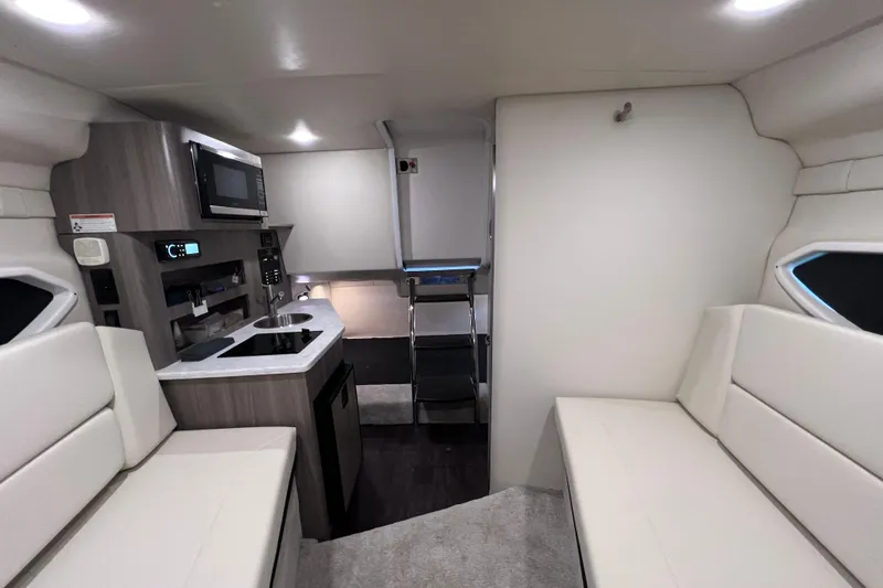Slide: The Image of Interior of a 2020 Regal 26 XO boat featuring a compact kitchen and seating area. - 45