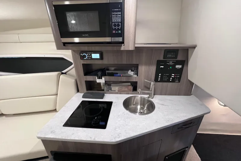 Slide: The Image of Compact kitchen area in a 2020 Regal 26 XO boat with modern amenities. - 52
