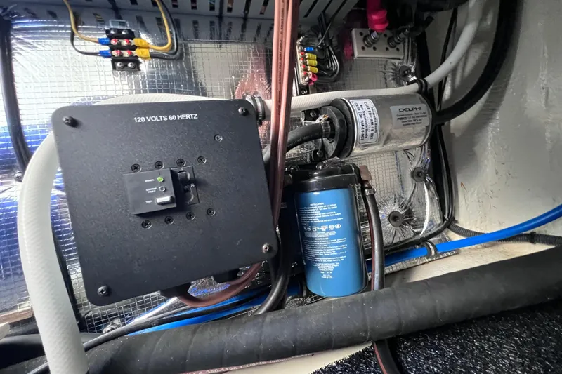 Slide: The Image of Electrical components inside a 2020 Regal 26 XO boat, featuring a 120 volts system. - 59