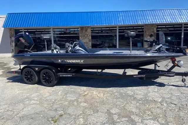 The Image of 2026 Phoenix 721 ZXL boat with trailer, parked outside a building with blue awning. - 1