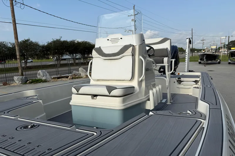 Slide: The Image of 2023 Skeeter SX240 boat interior with seating and console, parked outdoors. - 8
