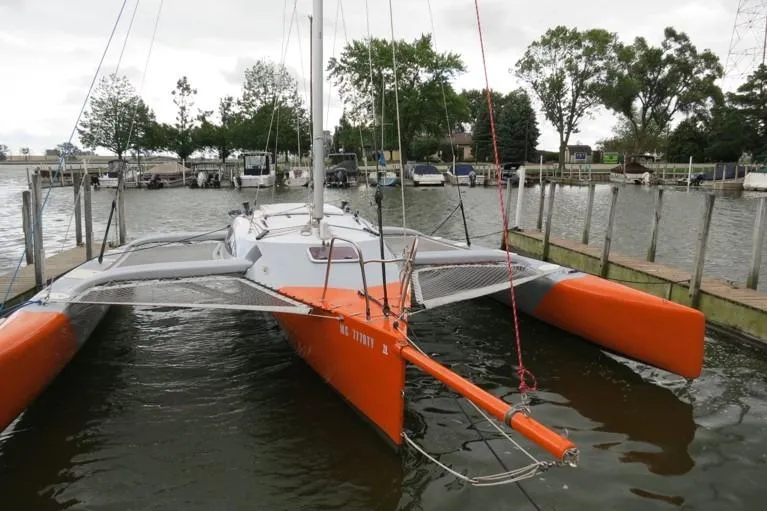 Slide: The Image of 2007 Farrier F-82R trimaran docked at a marina, featuring vibrant orange hulls. - 2