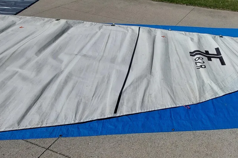 Slide: The Image of White sail from a 2007 Farrier F-82R, laid out on a blue tarp. - 44