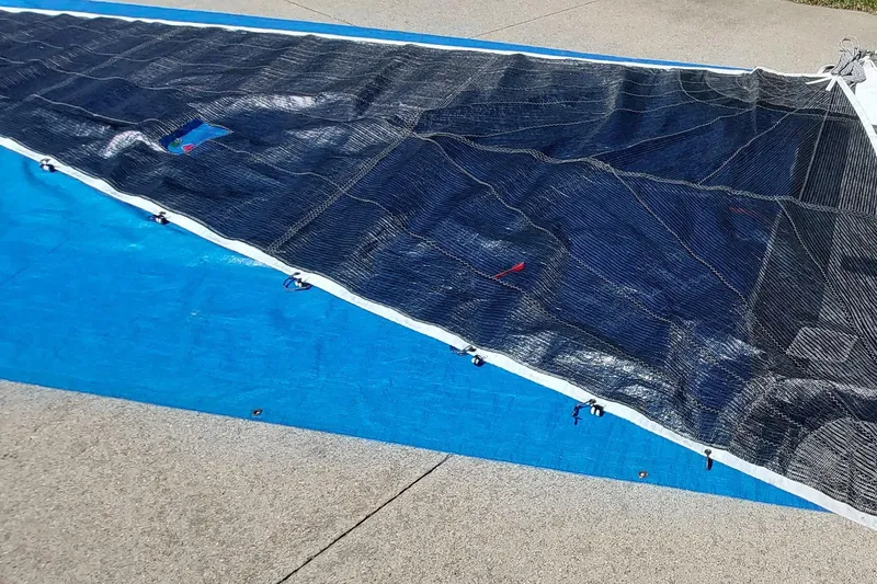 Slide: The Image of Sail laid out on pavement, Farrier F-82R model, 2007, with blue tarp underneath. - 49