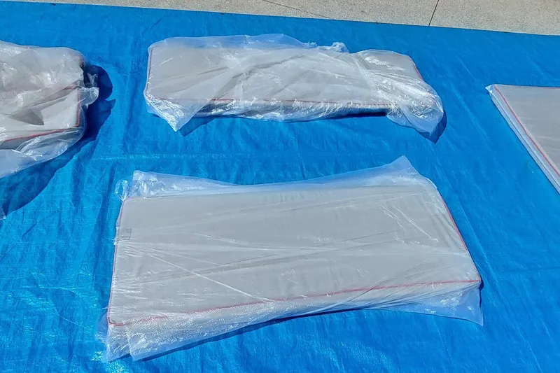 Slide: The Image of Parts of a Farrier F-82R 2007 model wrapped in plastic on a blue tarp. - 62
