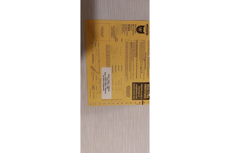 Slide: The Image of Yellow vehicle weight certificate on a wooden surface, Farrier F-82R, 2007 model. - 65