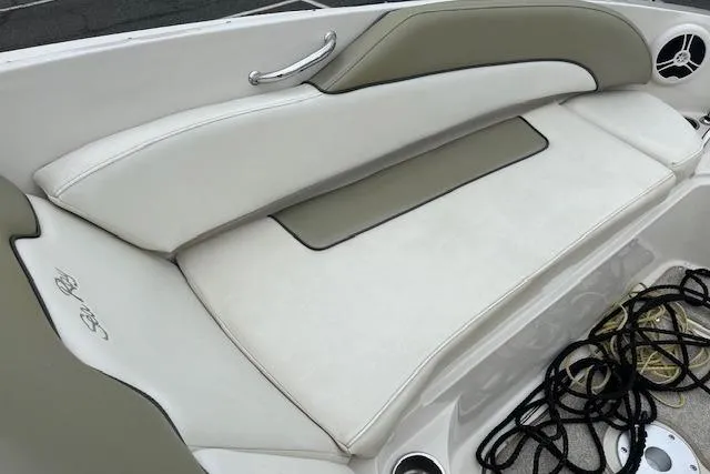 Slide: The Image of 2007 Sea Ray 260 Sundeck boat seating area with beige upholstery and storage space. - 11
