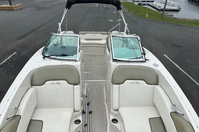 Slide: The Image of 2007 Sea Ray 260 Sundeck boat with spacious seating and sleek design, parked near a marina. - 13