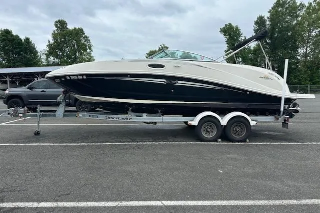 Slide: The Image of 2007 Sea Ray 260 Sundeck boat on trailer in parking lot, overcast sky. - 19