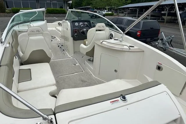 Slide: The Image of 2007 Sea Ray 260 Sundeck interior with spacious seating and helm, parked outdoors. - 27