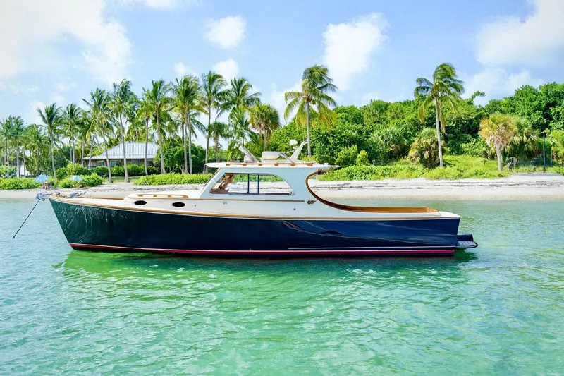 The Image of 2003 Hinckley Picnic Boat EP cruising near a tropical shoreline with palm trees. - 0