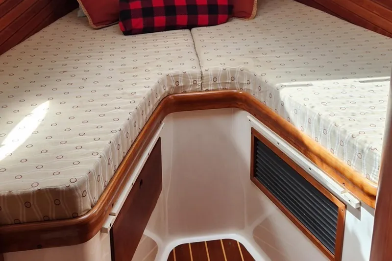 Slide: The Image of 2003 Hinckley Picnic Boat EP cabin interior with patterned cushions and wooden accents. - 12