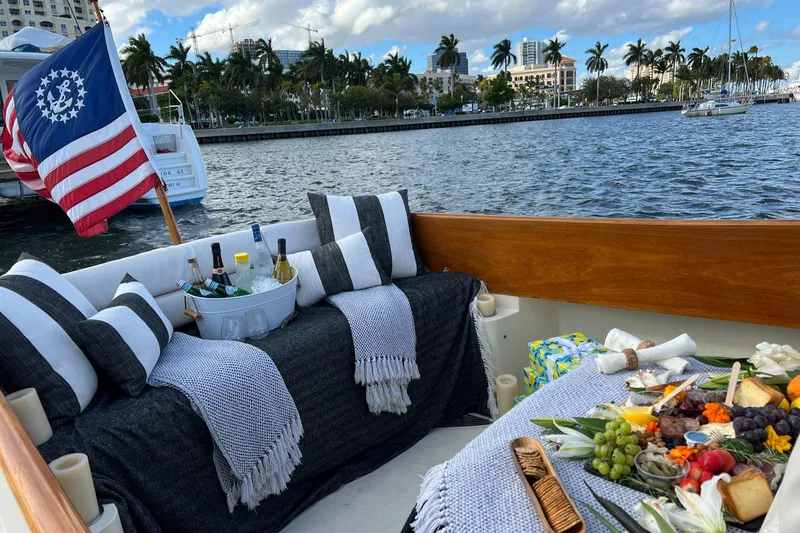 Slide: The Image of Luxurious 2003 Hinckley Picnic Boat EP with elegant seating and gourmet spread on deck. - 16