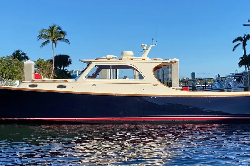Slide: The Image of 2003 Hinckley Picnic Boat EP on water, surrounded by palm trees and clear blue sky. - 21