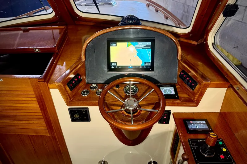 Slide: The Image of 2003 Hinckley Picnic Boat EP helm with wooden steering wheel and navigation display. - 5