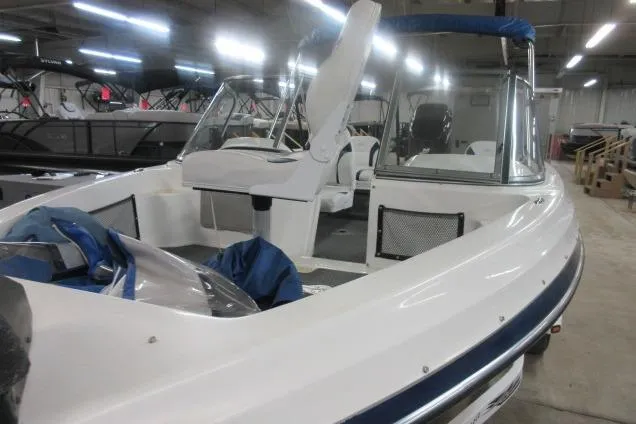 Slide: The Image of 2003 Sylvan V180 Viper OB boat in showroom, featuring white and blue design. - 2