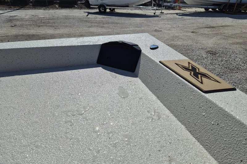 Slide: The Image of 2026 Xpress H20B Bay boat deck with textured surface and logo detail. - 14