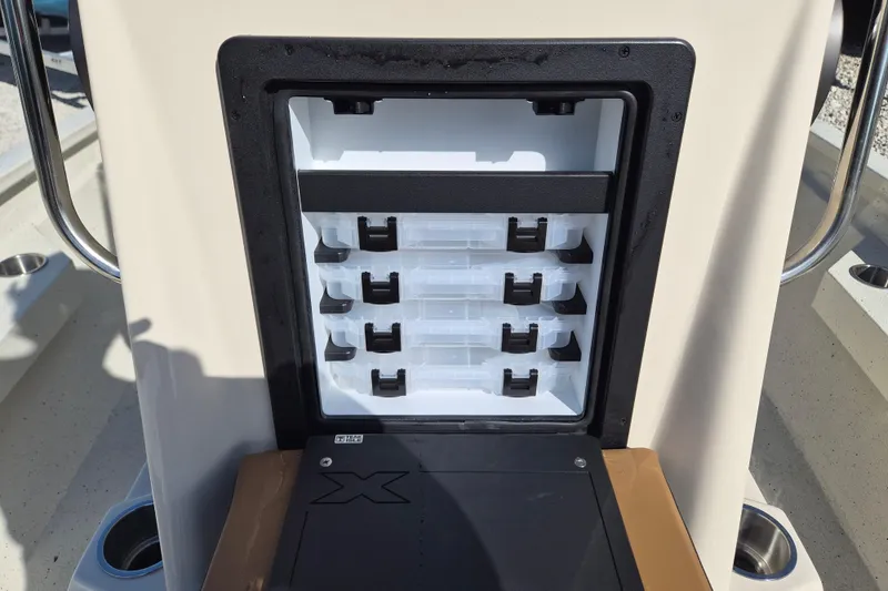 Slide: The Image of 2026 Xpress H20B Bay boat storage compartment with organized tackle boxes. - 17