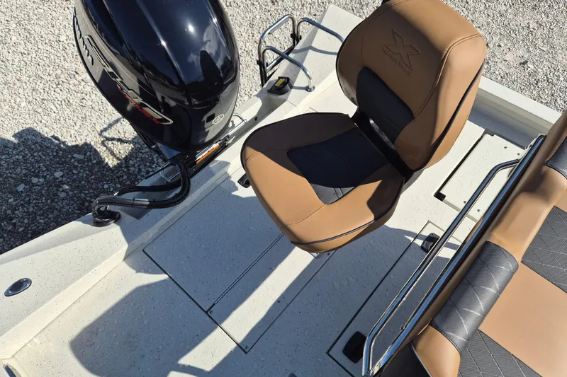 Slide: The Image of 2026 Xpress H20B Bay boat interior with tan seating and black motor. - 6