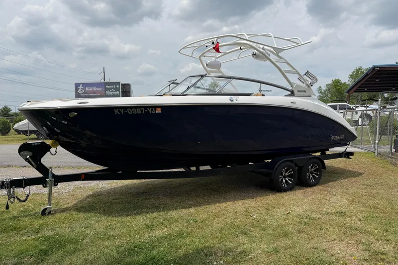 Slide: The Image of 2022 Yamaha Boats 252SE on trailer, parked outdoors under cloudy sky. - 16