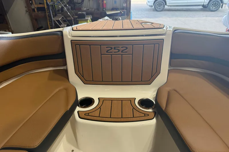 Slide: The Image of 2026 Yamaha Boats 252SD interior with brown seating and wood accents. - 10