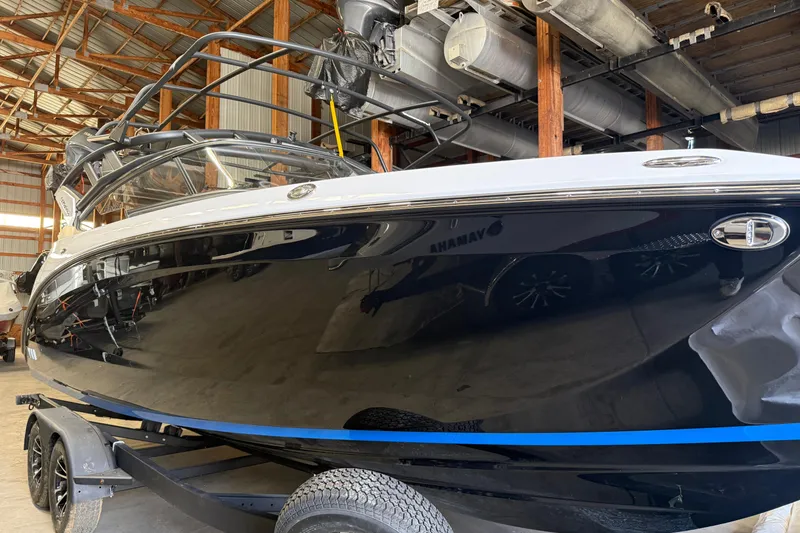 Slide: The Image of 2026 Yamaha Boats 252SD in a warehouse, sleek black hull on a trailer. - 2