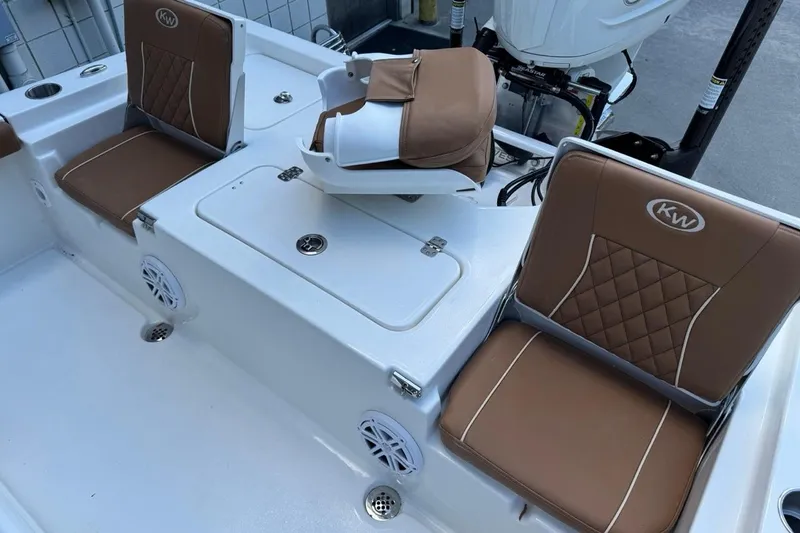 Slide: The Image of 2026 Key West 230 Bay Reef boat interior with brown cushioned seats and storage compartments. - 12