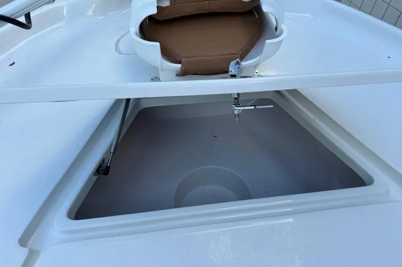 Slide: The Image of Open storage compartment on 2026 Key West 230 Bay Reef boat with cushioned seat. - 19