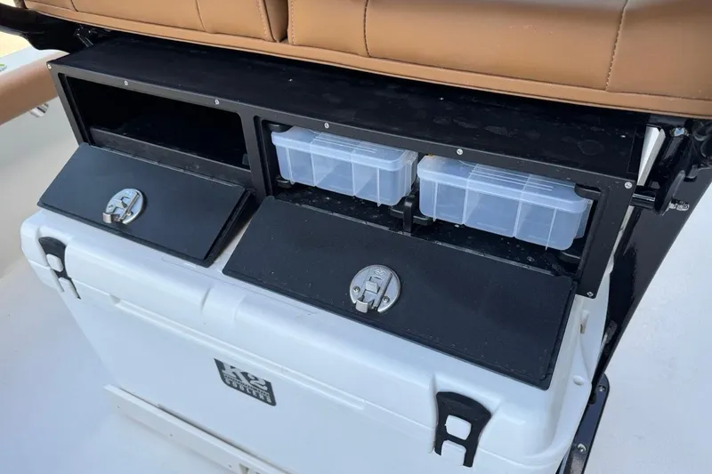 Slide: The Image of 2026 Key West 230 Bay Reef boat storage compartments with tackle boxes and cooler. - 33