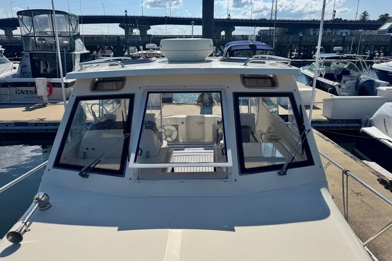 Slide: The Image of 2004 Mainship Pilot 30-II docked at marina, showcasing cabin and windshield. - 11