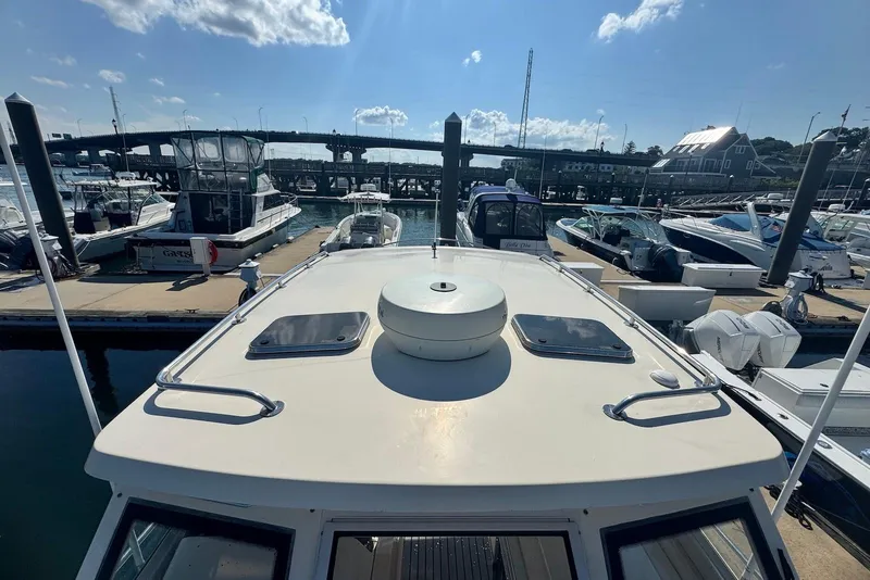 Slide: The Image of 2004 Mainship Pilot 30-II docked at a marina under a clear blue sky. - 12