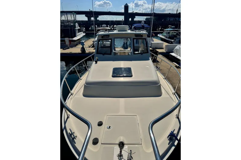 Slide: The Image of 2004 Mainship Pilot 30-II docked at marina, showcasing bow and cabin. - 13