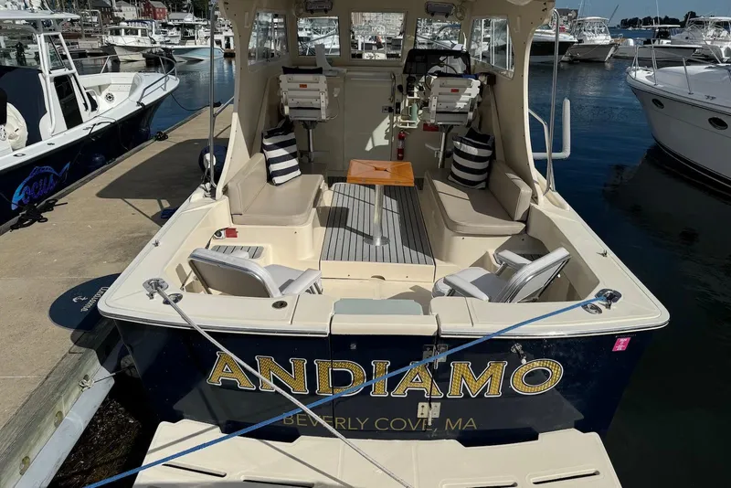 Slide: The Image of 2004 Mainship Pilot 30-II boat docked, featuring spacious seating and striped cushions. - 16