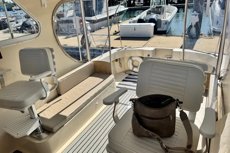 Slide: The Image of Interior of a 2004 Mainship Pilot 30-II boat with seating and harbor view. - 18
