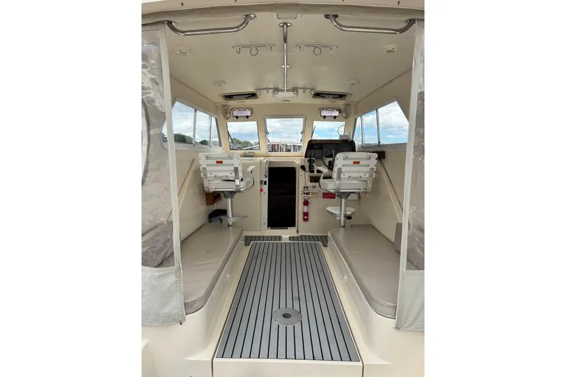 Slide: The Image of 2004 Mainship Pilot 30-II interior with helm seats and panoramic windows. - 19