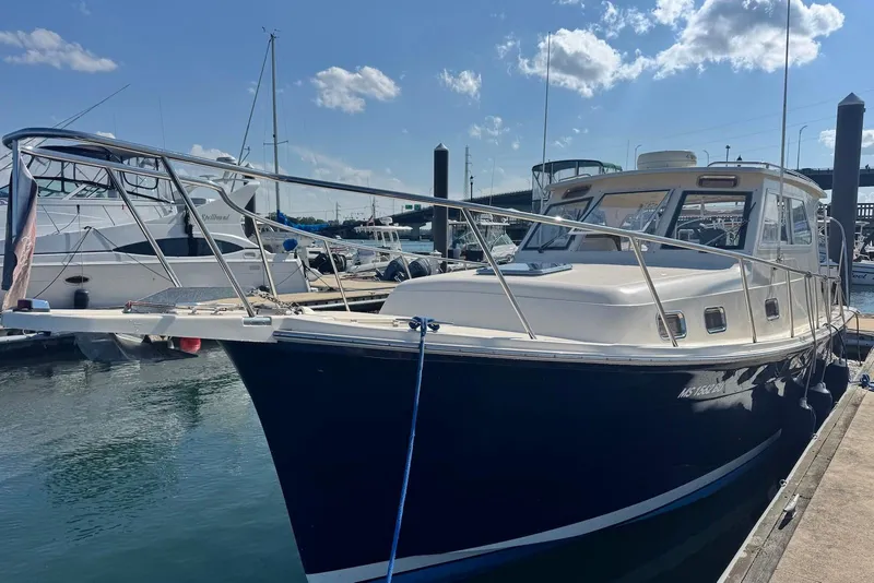Slide: The Image of 2004 Mainship Pilot 30-II docked at marina under clear blue sky. - 2