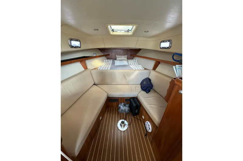 Slide: The Image of 2004 Mainship Pilot 30-II cabin interior with beige seating and wood accents. - 23