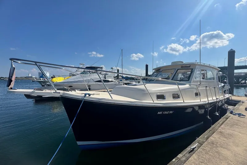 Slide: The Image of 2004 Mainship Pilot 30-II docked at marina under clear blue sky. - 3