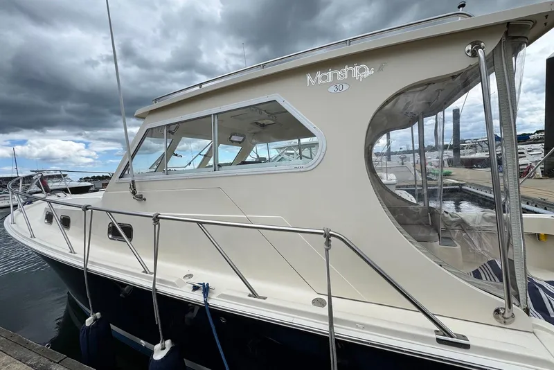 Slide: The Image of 2004 Mainship Pilot 30-II boat docked at marina under cloudy sky. - 5