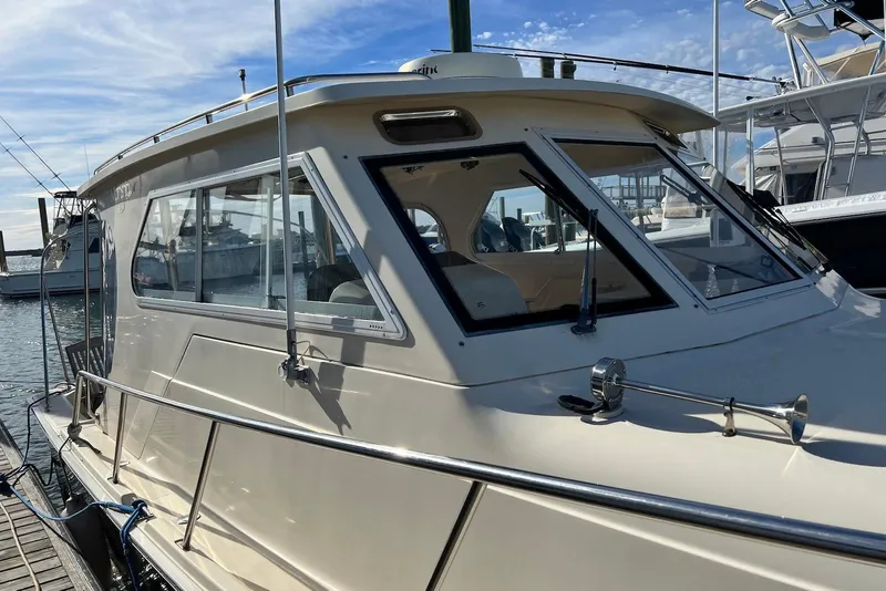 Slide: The Image of 2004 Mainship Pilot 30-II docked, showcasing sleek design and spacious cabin. - 7