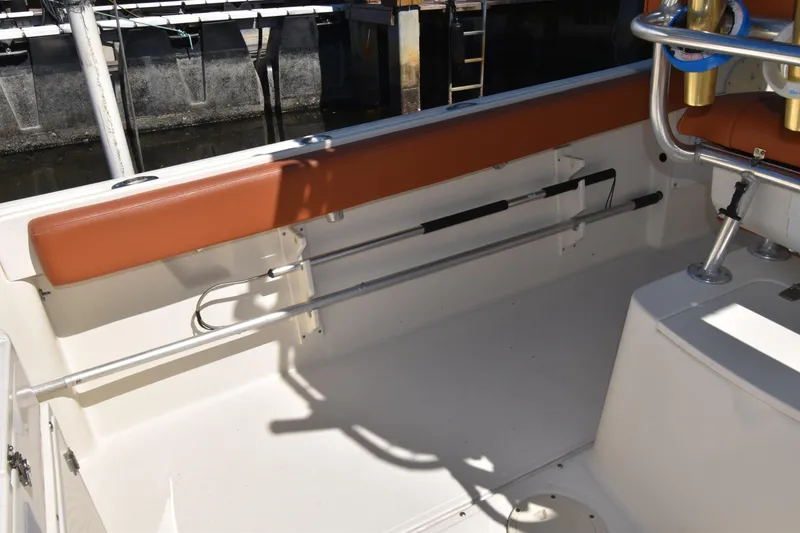 Slide: The Image of 2001 Pursuit 2470 Center Console boat interior with fishing rod holders and seating. - 15