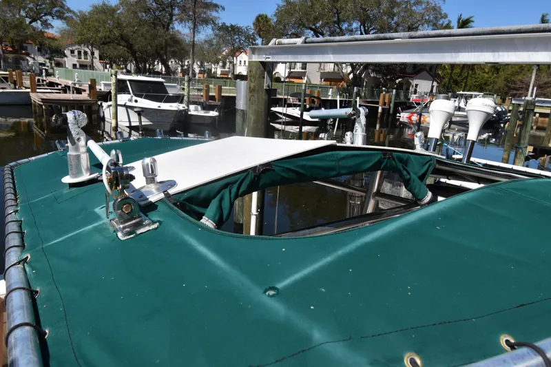 Slide: The Image of 2001 Pursuit 2470 Center Console boat docked, featuring green canvas cover and marina background. - 18