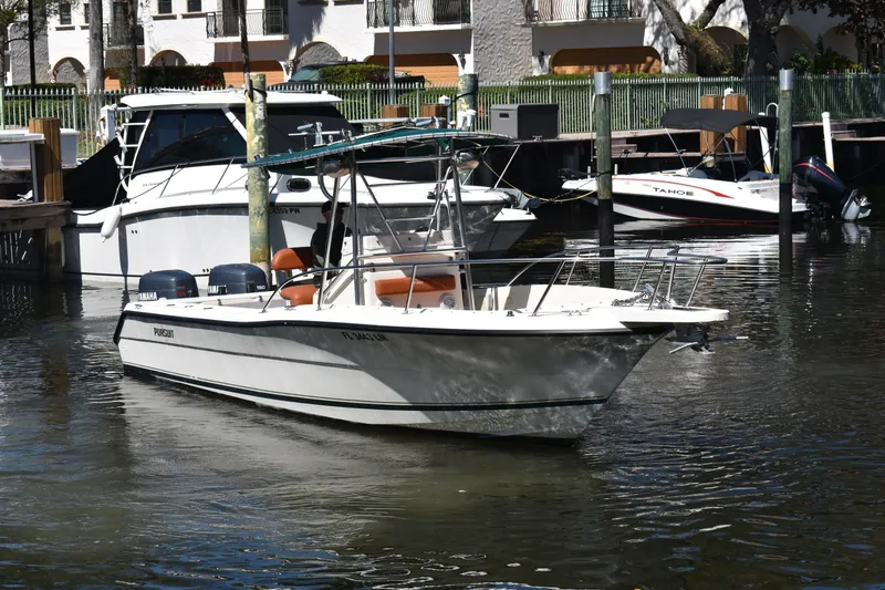 Slide: The Image of 2001 Pursuit 2470 Center Console boat docked in a marina with other vessels. - 3
