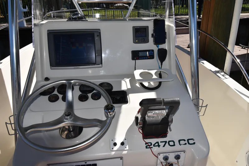 Slide: The Image of Center console of a 2001 Pursuit 2470 boat with steering wheel and navigation equipment. - 6