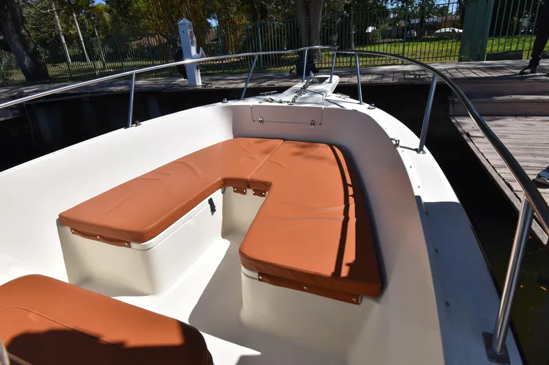 Slide: The Image of 2001 Pursuit 2470 Center Console boat with brown cushioned seating at the bow. - 7