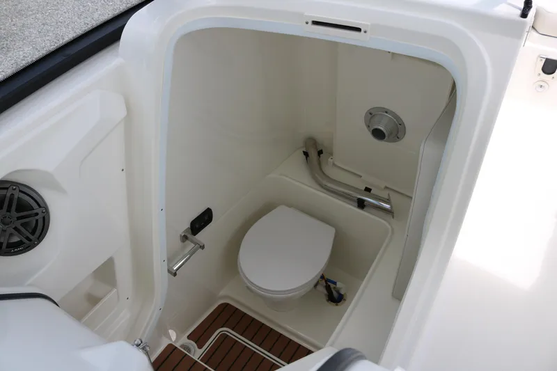 Slide: The Image of Interior of 2026 World Cat 265 DC-X boat, featuring a compact marine toilet. - 11