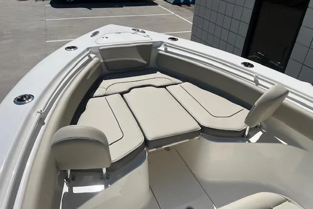 Slide: The Image of 2026 Key West 239 FS boat interior with cushioned seating in a marina setting. - 18
