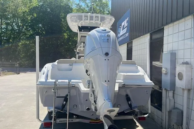 Slide: The Image of 2026 Key West 239 FS boat with outboard motor, parked outside a building. - 3
