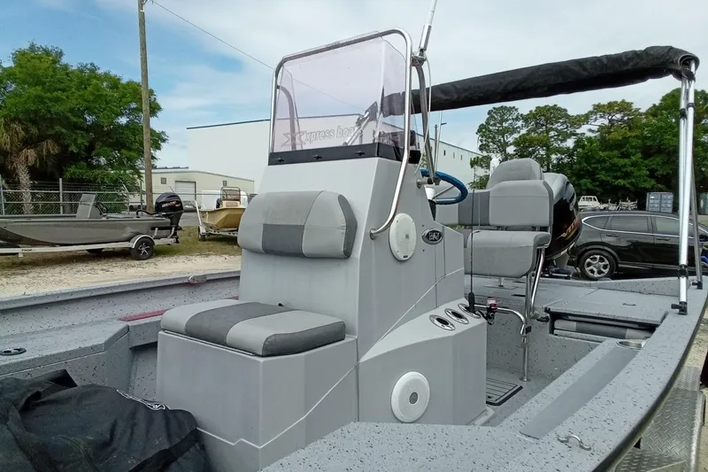 Slide: The Image of 2021 Xpress H20B Bay boat interior with seating and console, parked outdoors. - 6