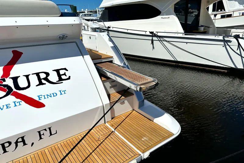 Slide: The Image of 2015 Azimut 55S yacht docked, featuring teak decking and custom graphics, Tampa, FL. - 14